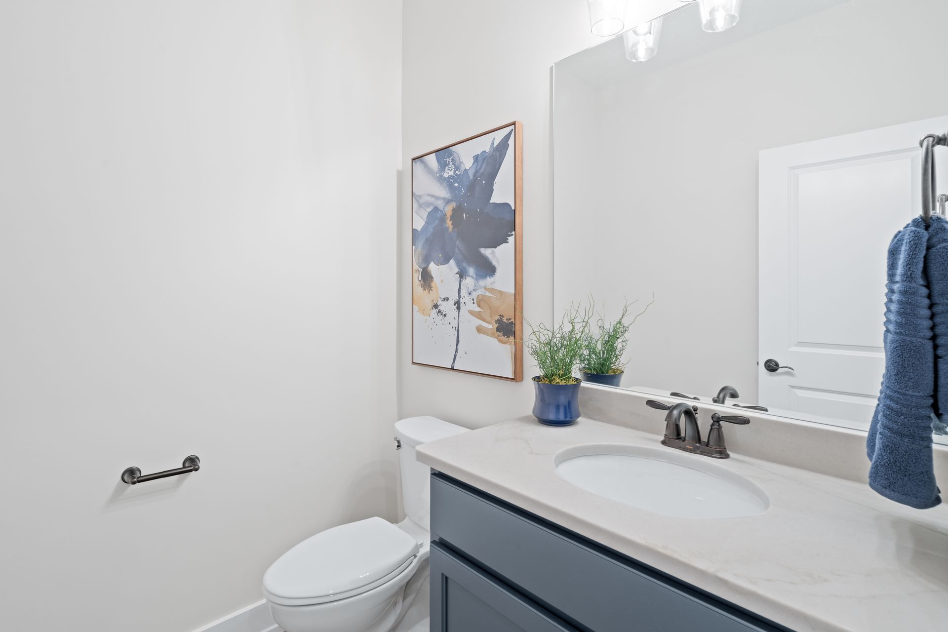 A bathroom with a toilet , sink and mirror.