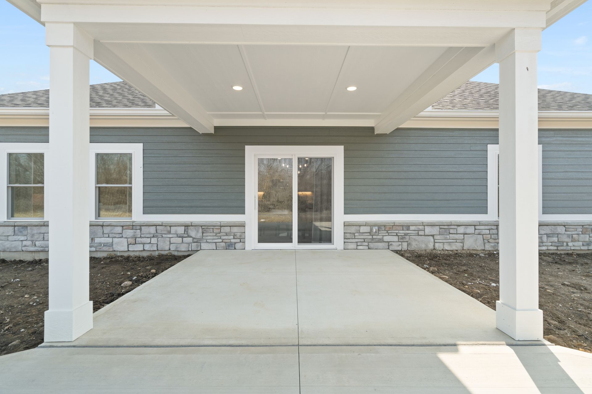 The front of a house with a covered walkway leading to the door.