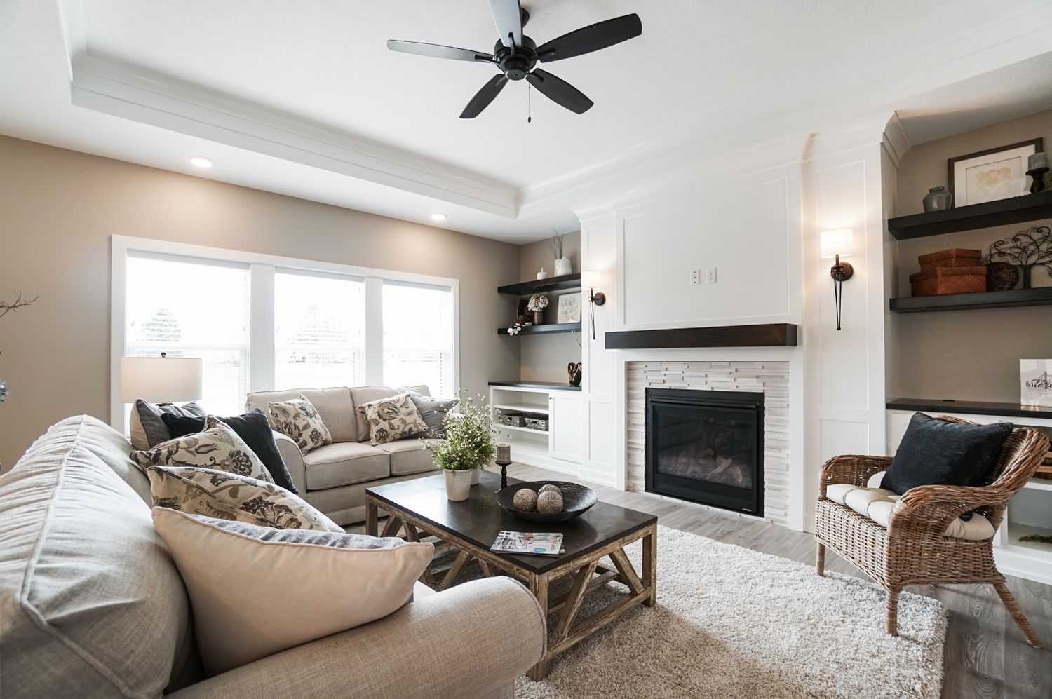 A living room with a fireplace and a ceiling fan.