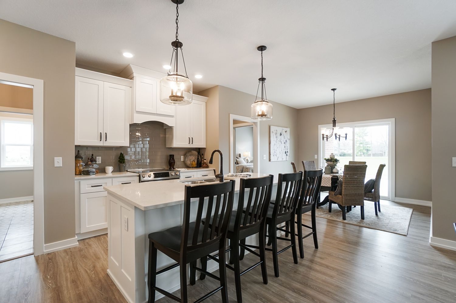 A kitchen with a large island and chairs in a house.