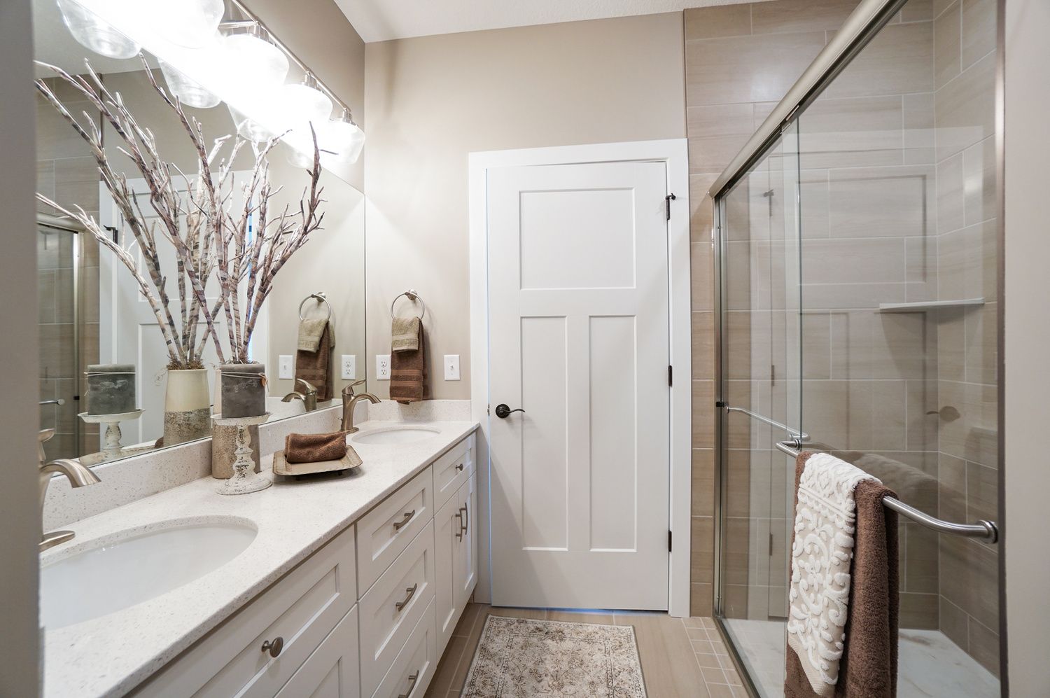 A bathroom with two sinks and a walk in shower.