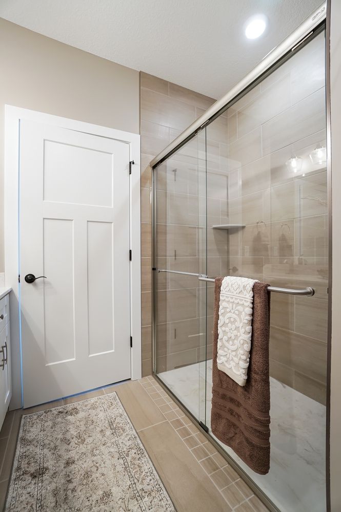 A bathroom with a walk in shower and sliding glass doors.