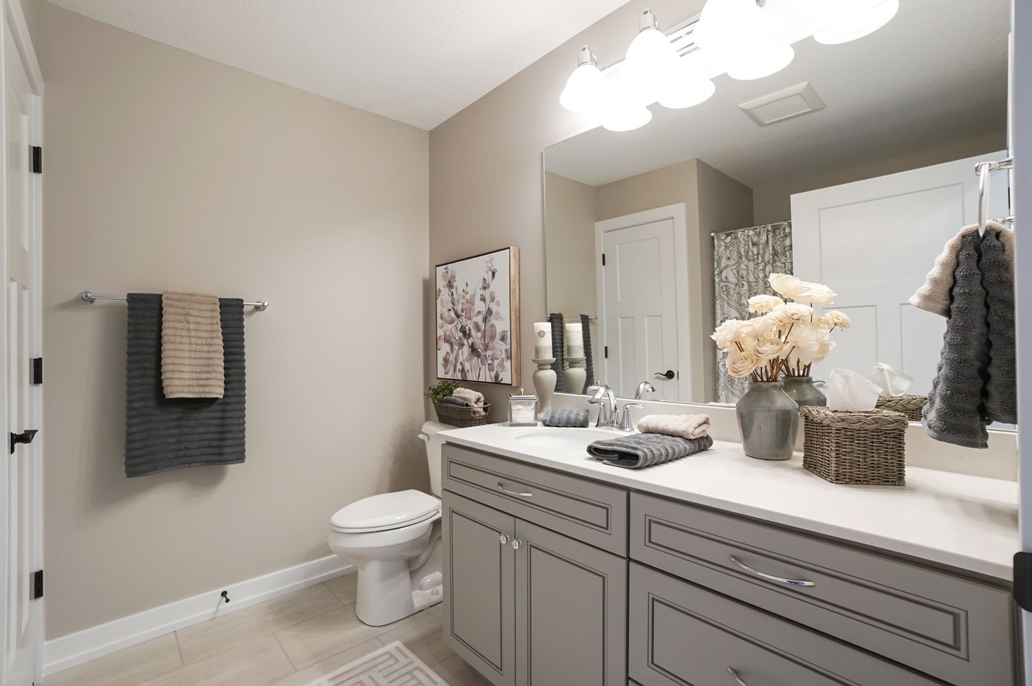 A bathroom with a toilet , sink , and mirror.