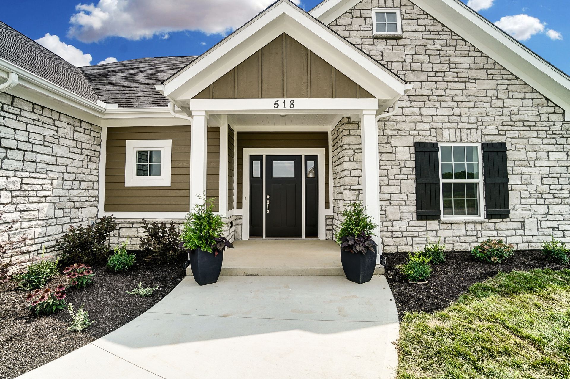 A brick house with a porch and a black door