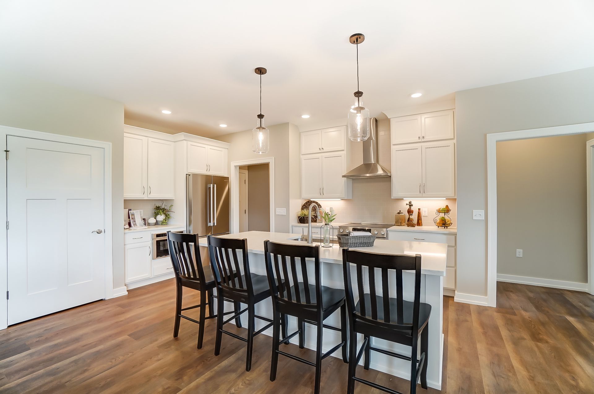A kitchen with a large island and chairs in it.