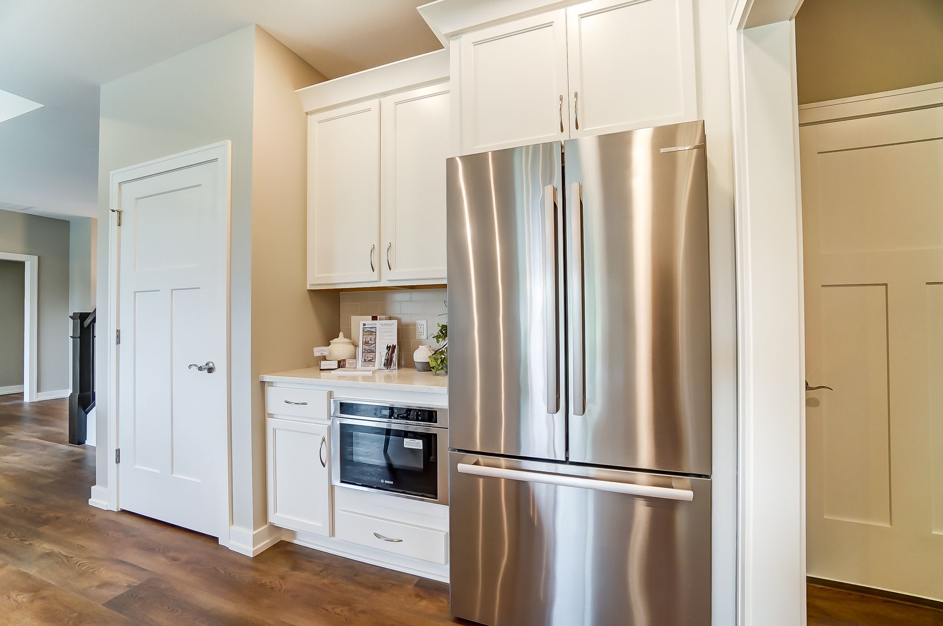 A kitchen with stainless steel appliances and white cabinets.