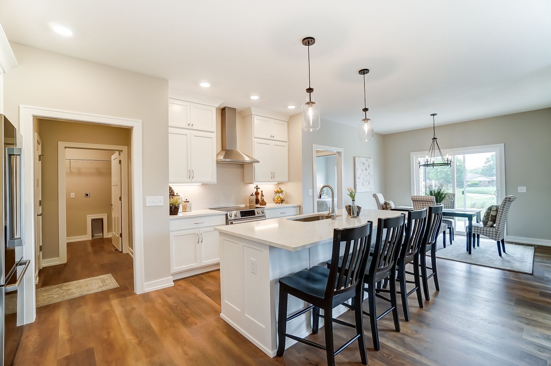 A kitchen with a large island and stools in a house.