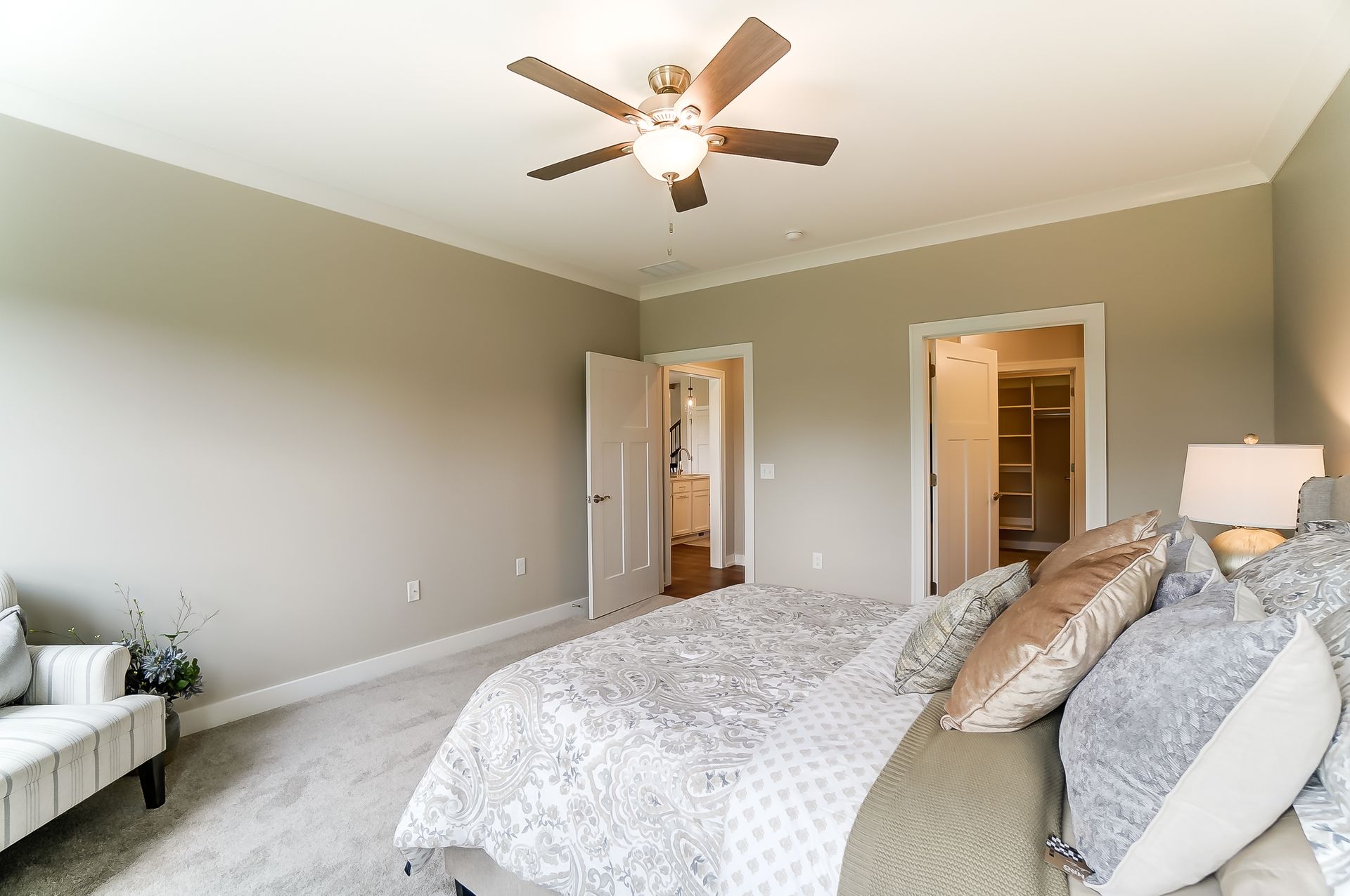 A bedroom with a bed and a ceiling fan.