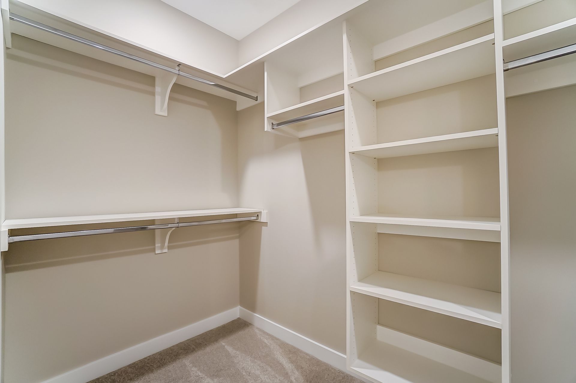 A walk in closet with lots of shelves and clothes racks.