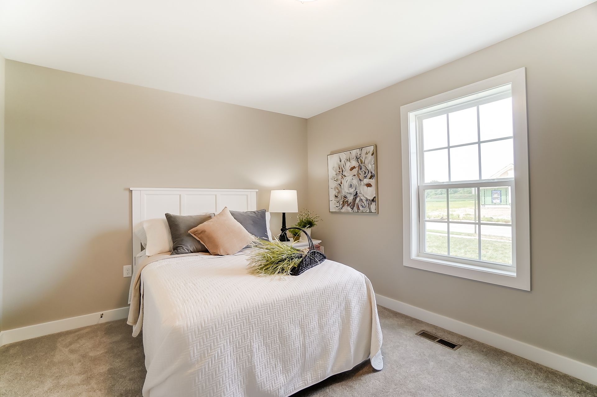 A bedroom with a bed , two windows and a lamp.