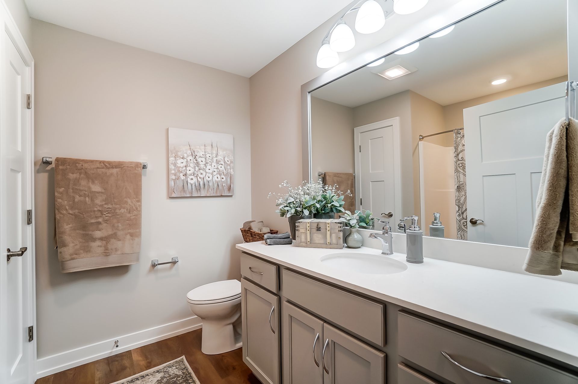 A bathroom with a toilet , sink , and mirror.