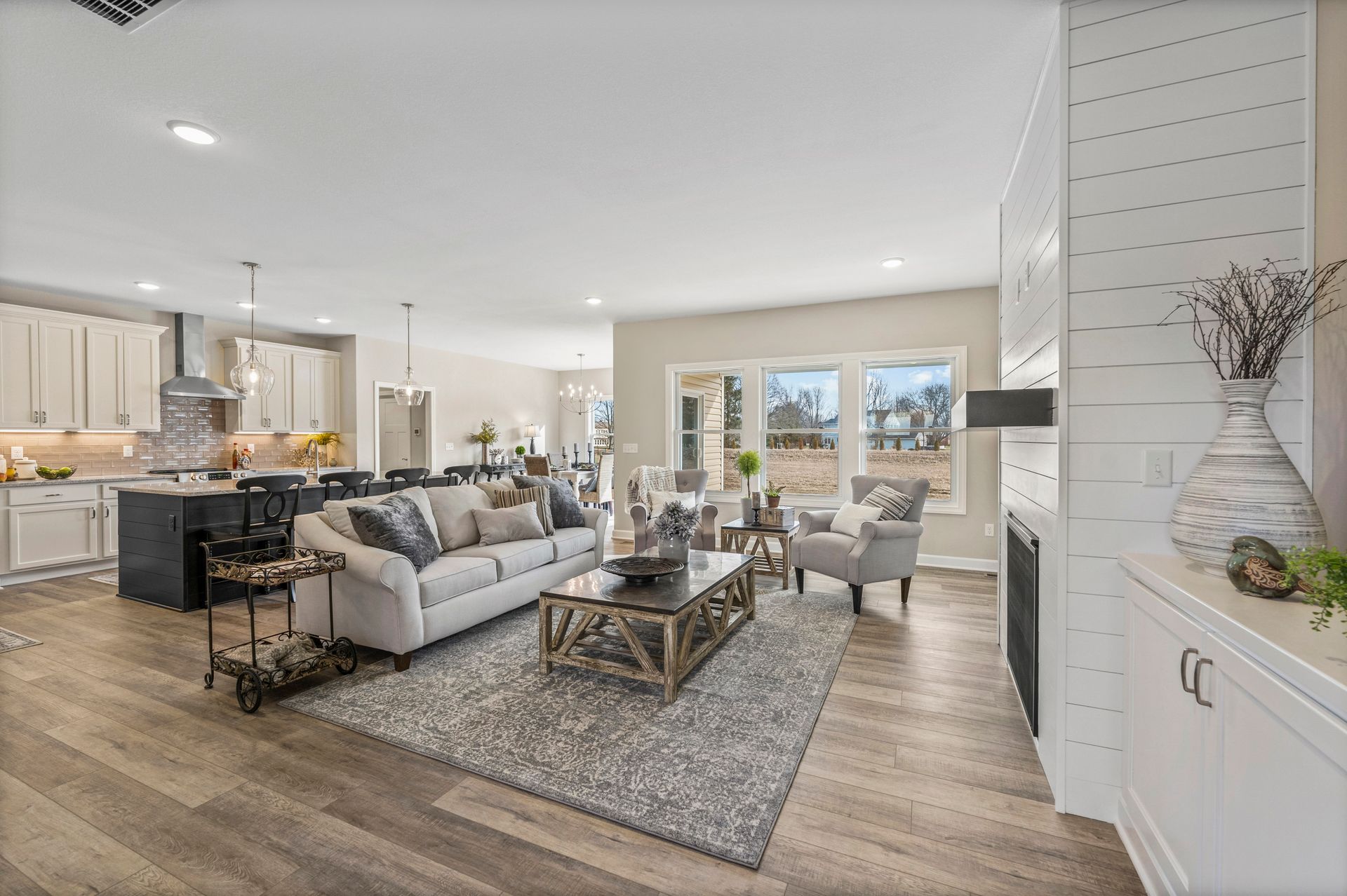 A living room with a couch , coffee table , chairs and a fireplace.