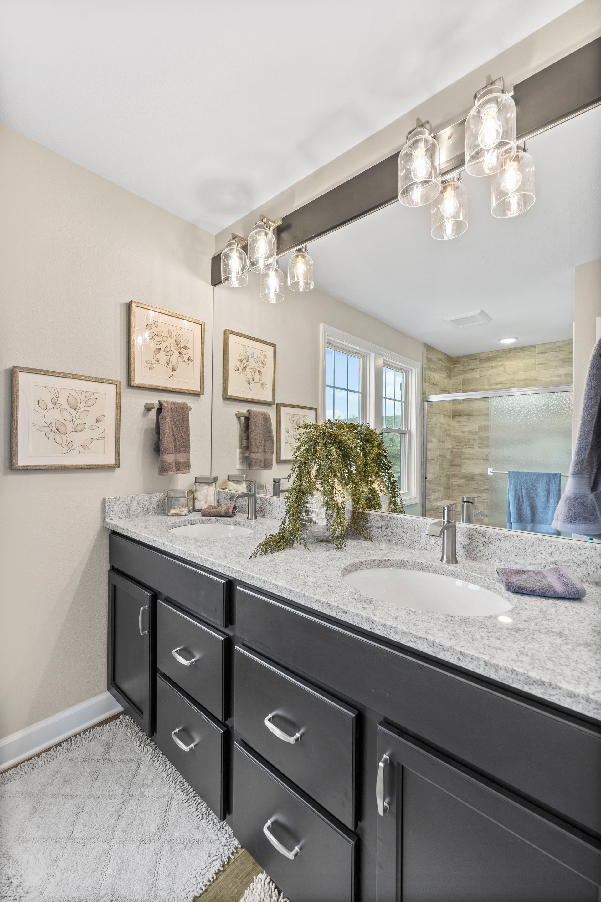 A bathroom with a double sink and a large mirror.