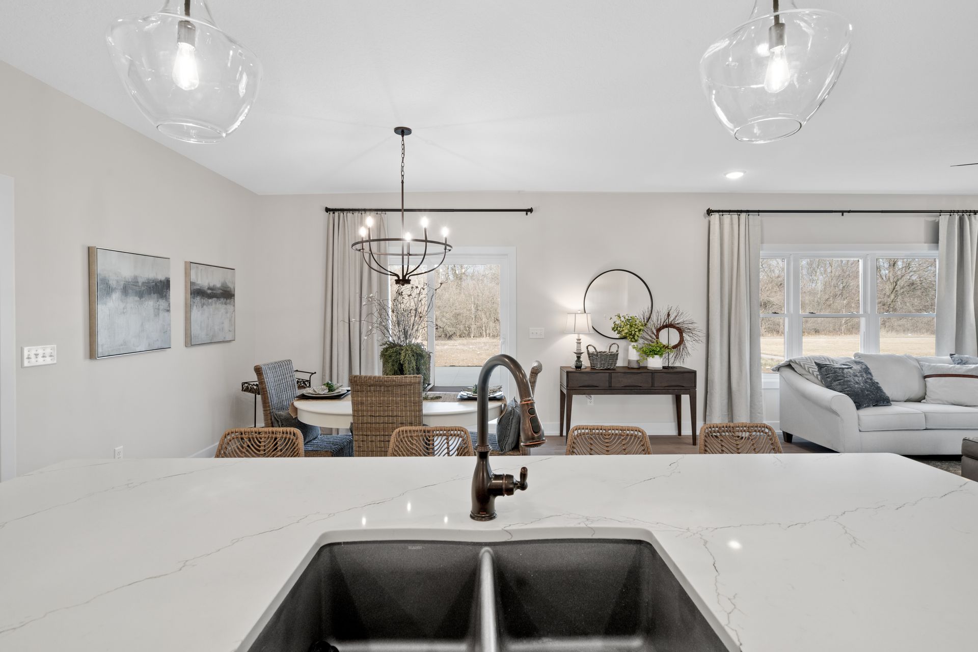 A kitchen with a sink and a dining room in the background.