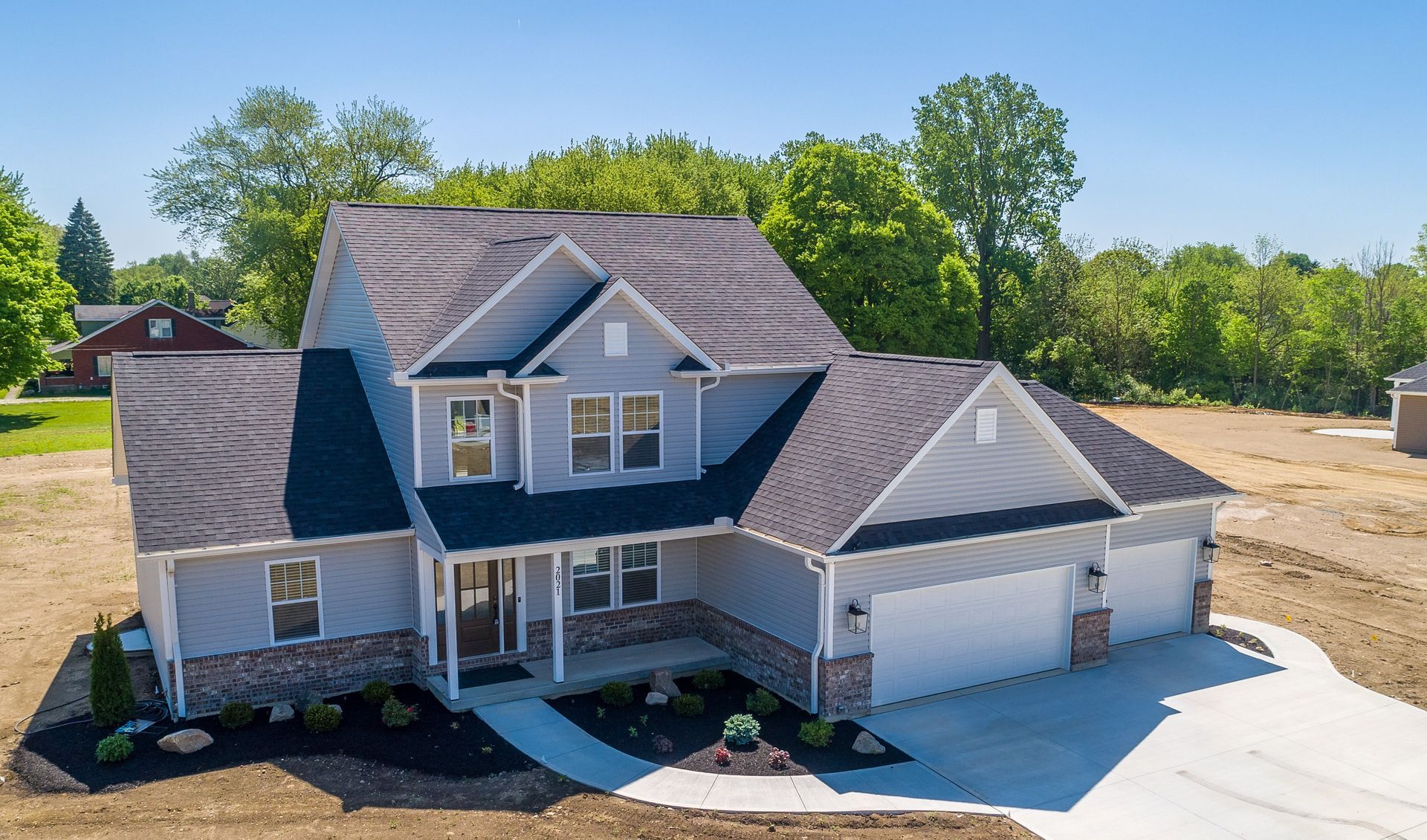An aerial view of a large house with a gray roof