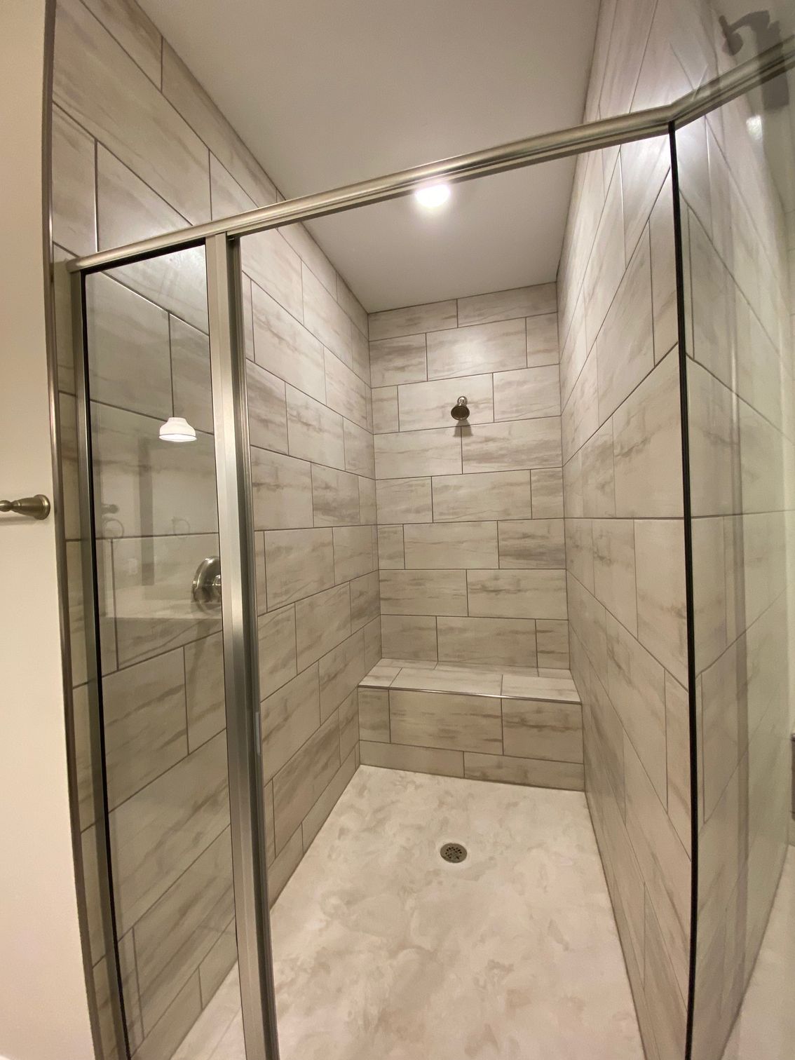 A bathroom with a walk in shower with a sliding glass door.