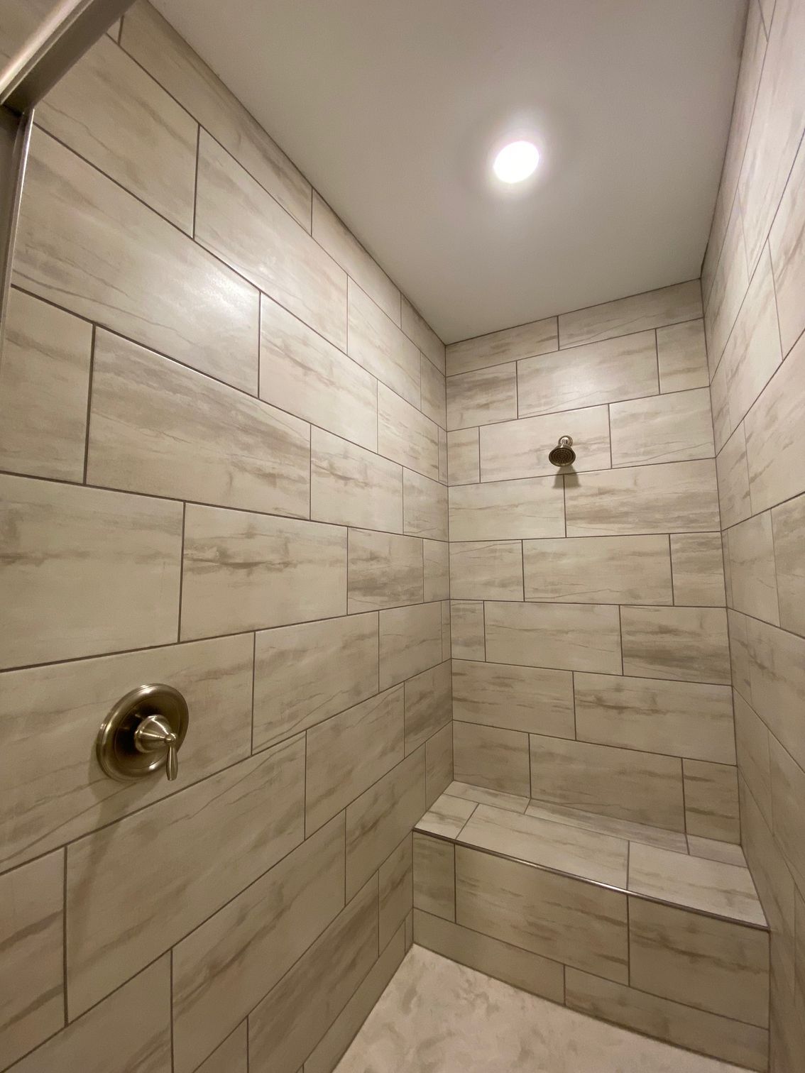 A bathroom with a shower and a bench in it
