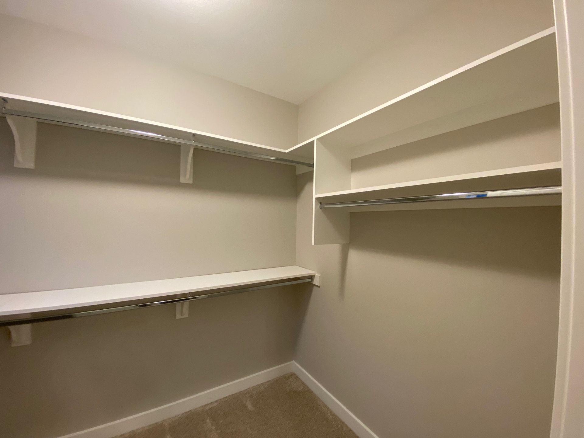 A walk in closet with lots of shelves and racks.