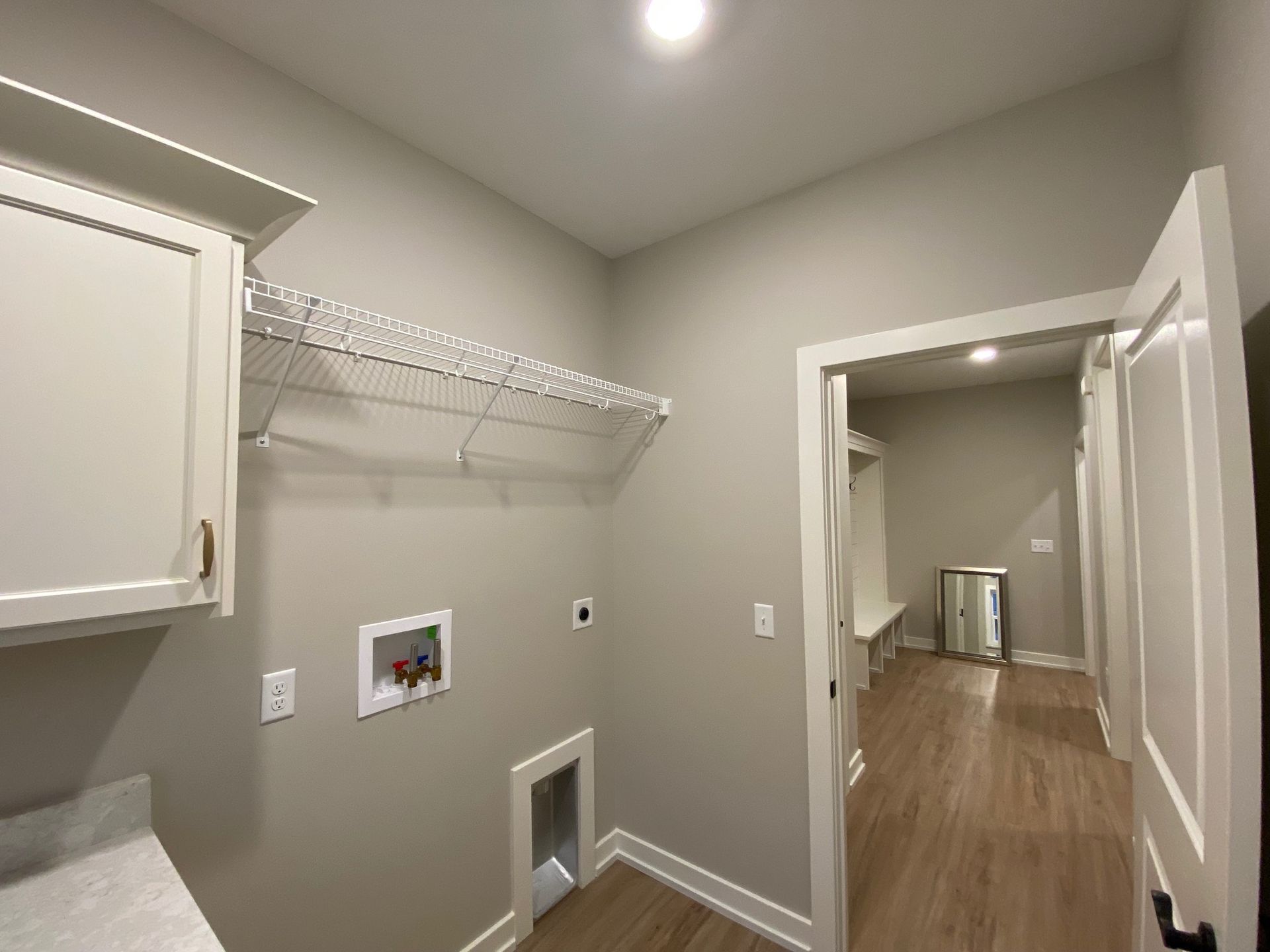 A laundry room with a washer and dryer and a cat door.