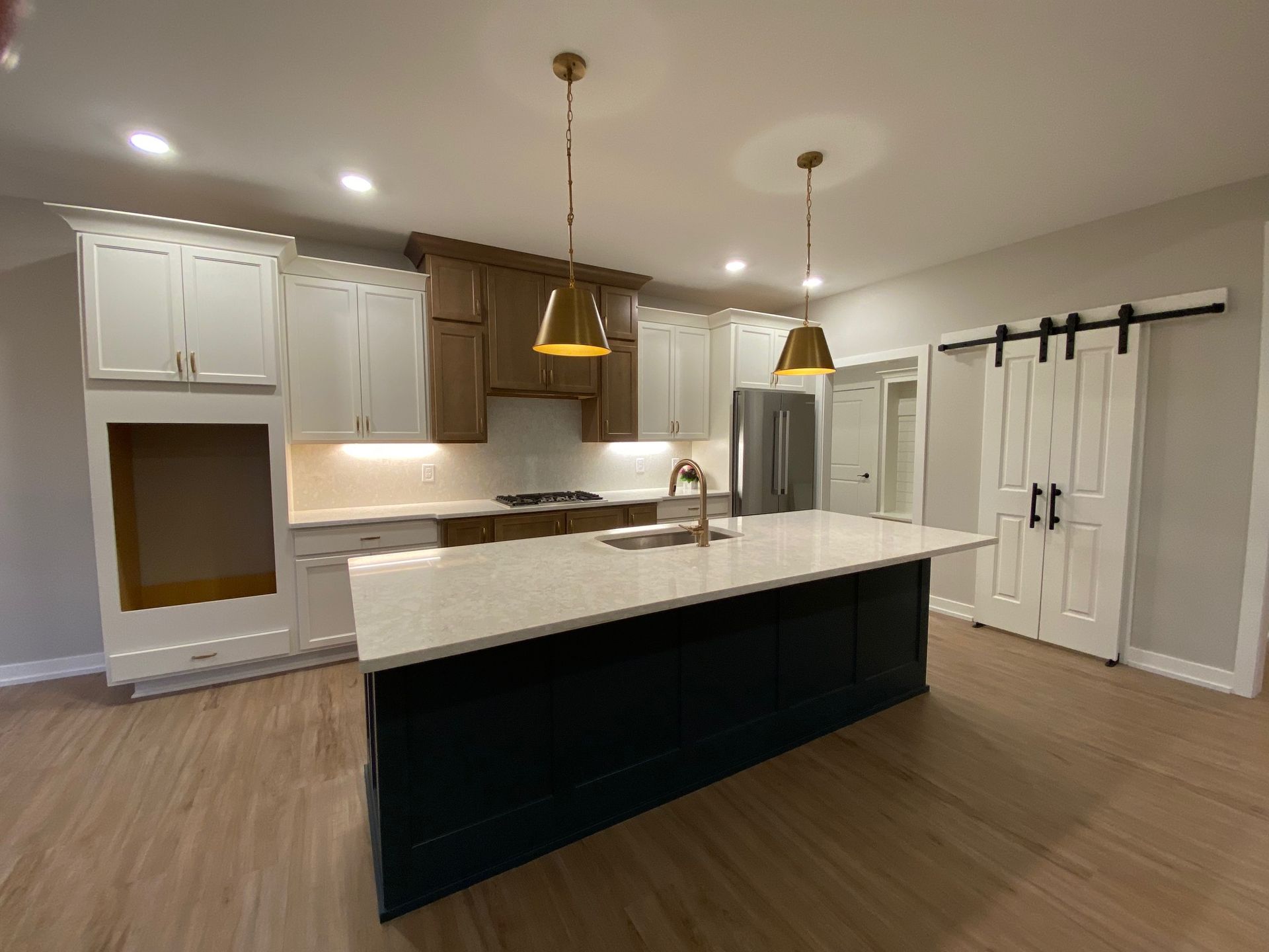 A kitchen with a large island and sliding barn doors.