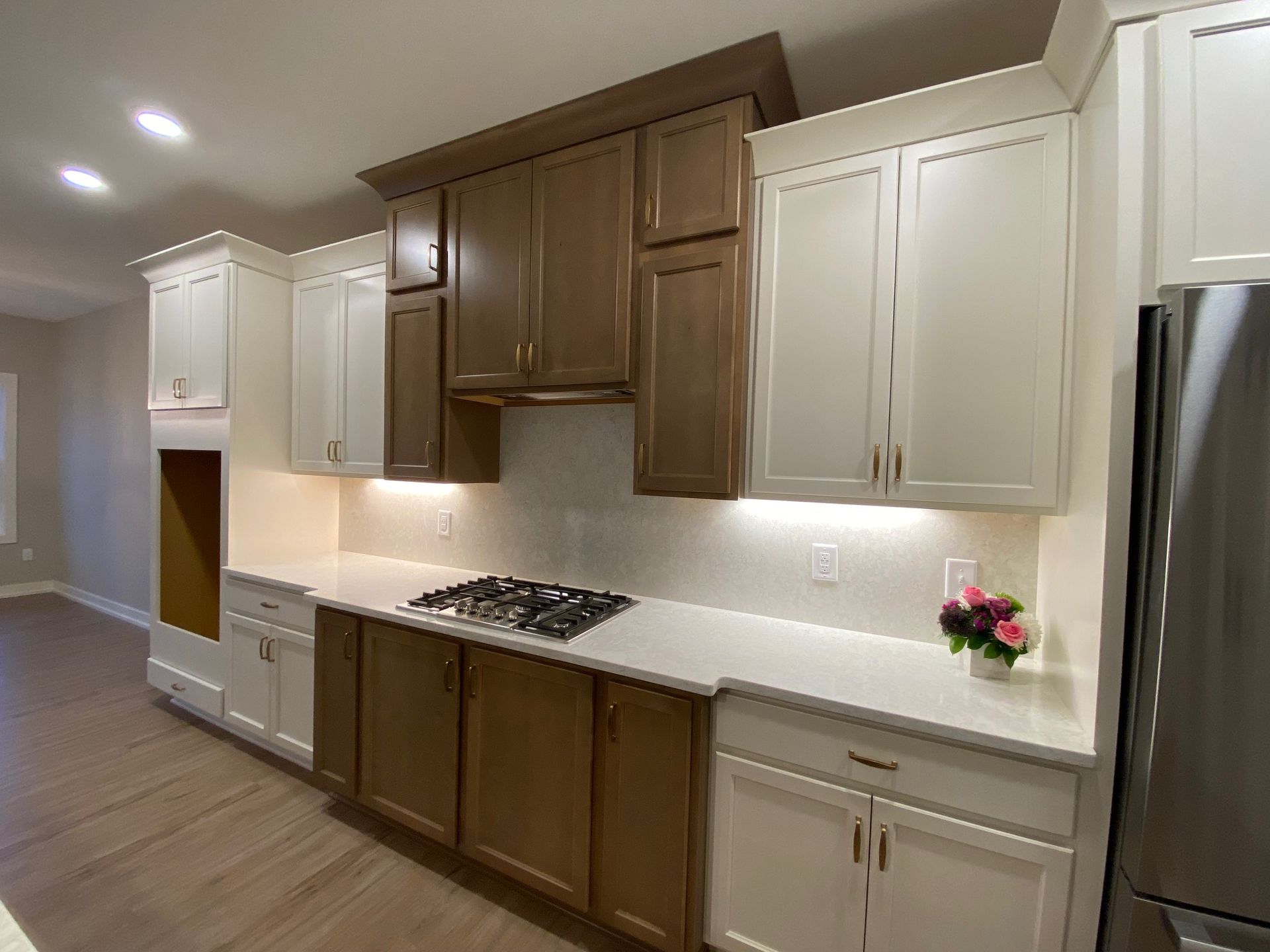 A kitchen with brown cabinets and white counter tops and a stove top oven.