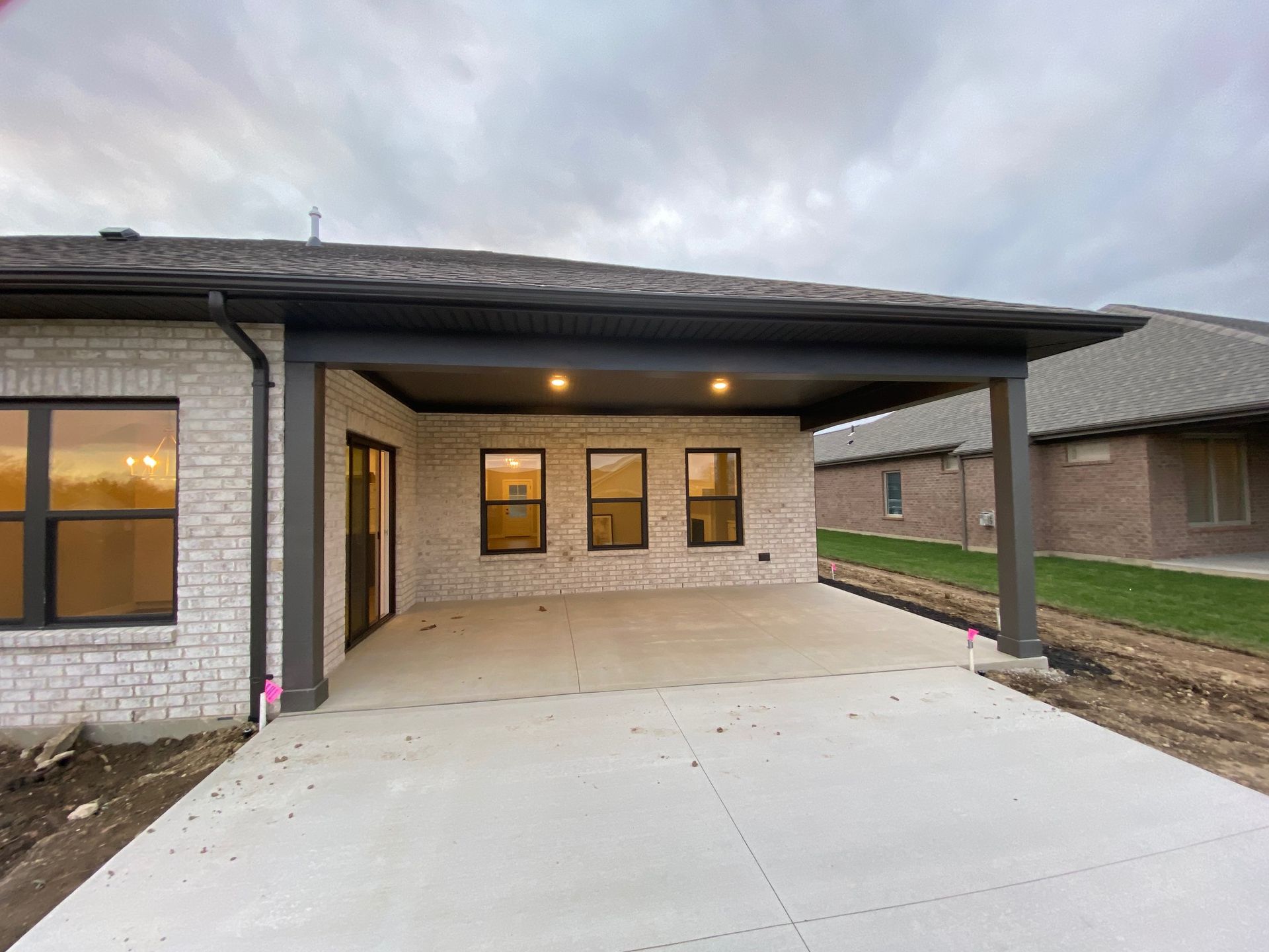 A brick house with a covered driveway in front of it.