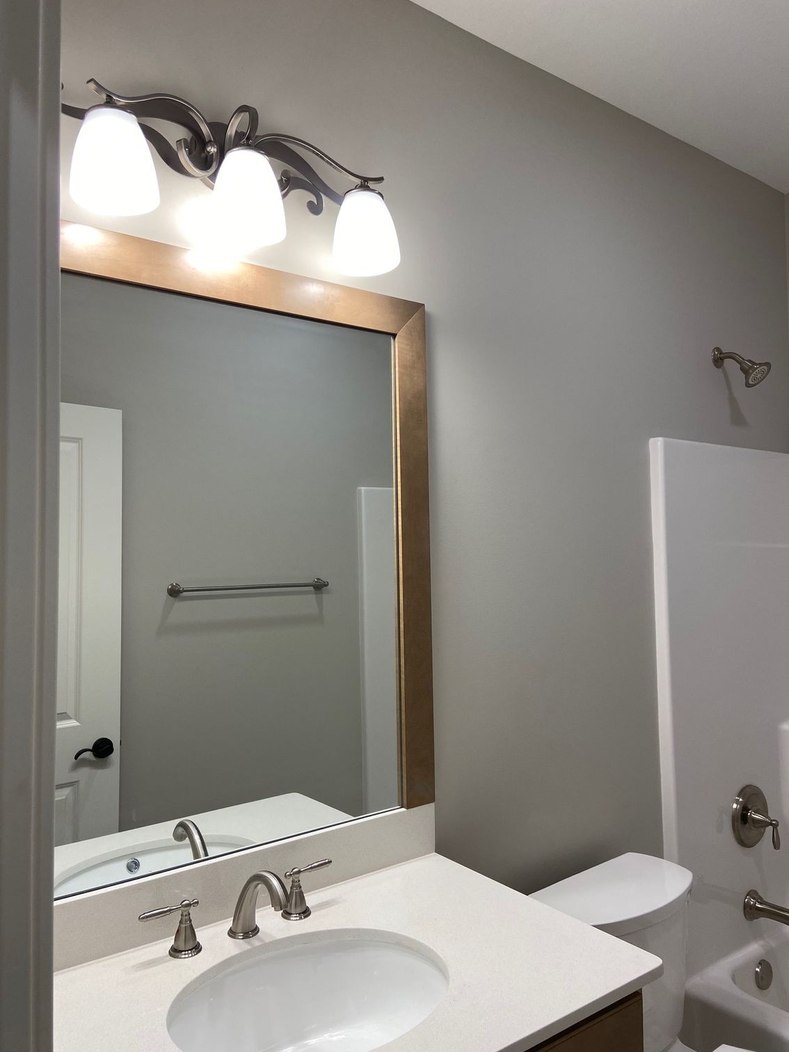 A bathroom with a sink , toilet , shower and mirror