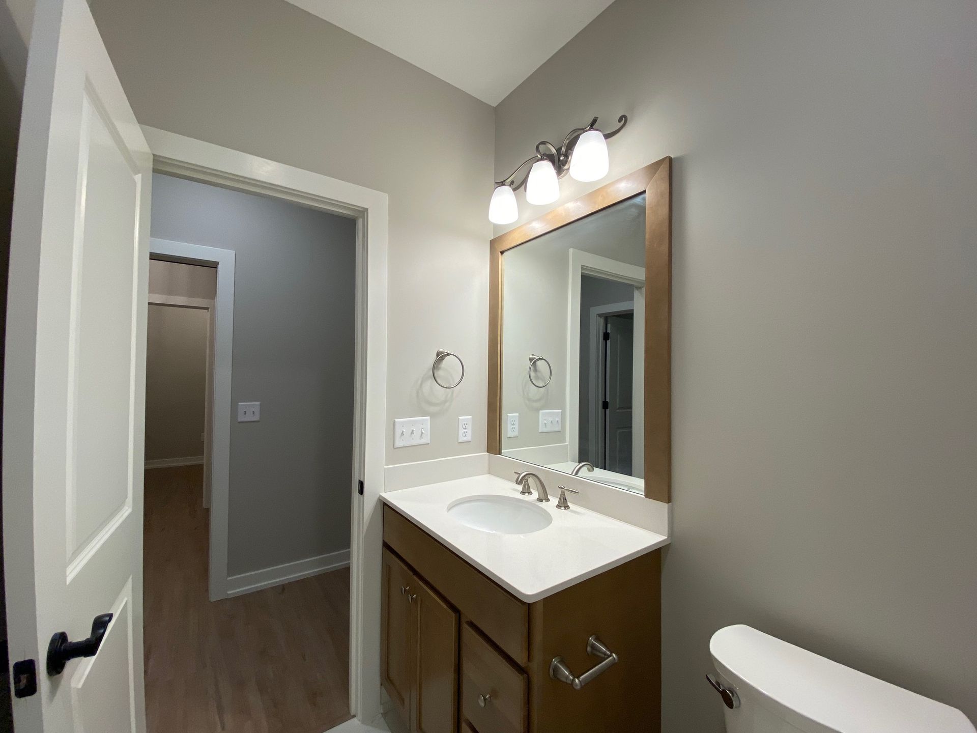 A bathroom with a sink , mirror and toilet.