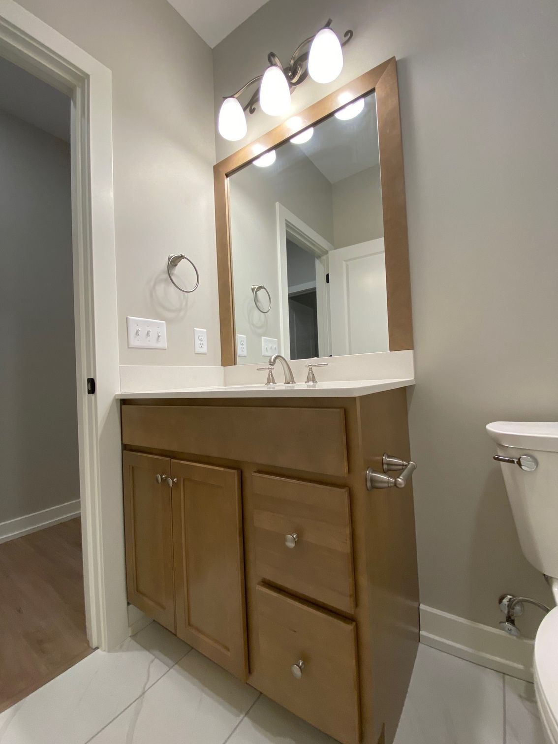 A bathroom with a sink , toilet and mirror.