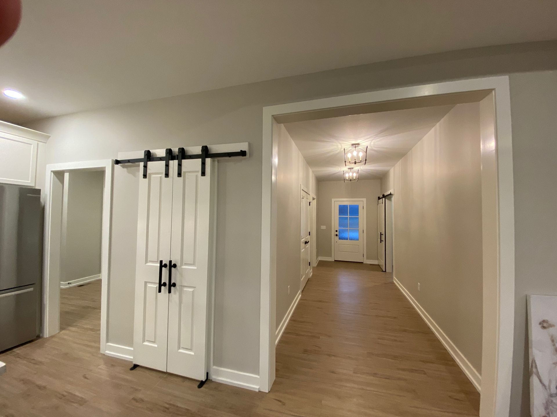 A long hallway with sliding barn doors in a house.