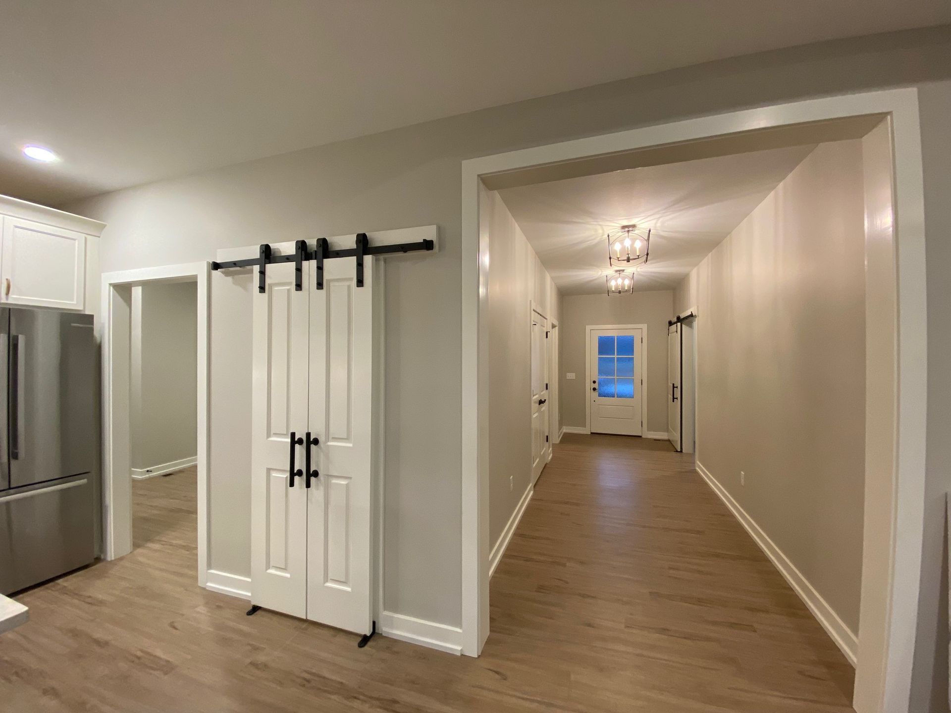 There is a sliding barn door in the hallway between the kitchen and the living room.