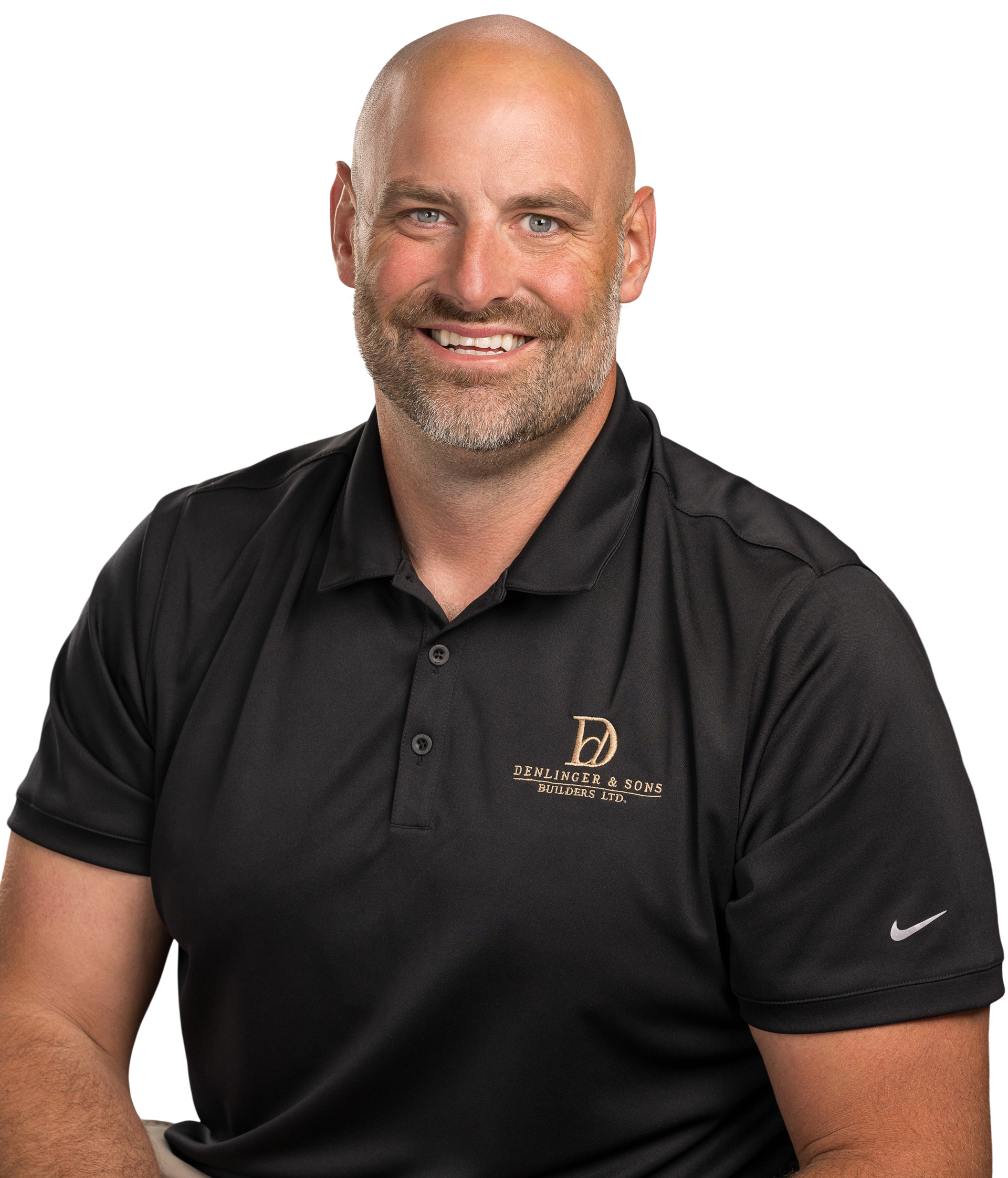 A bald man with a beard is wearing a black polo shirt and smiling.