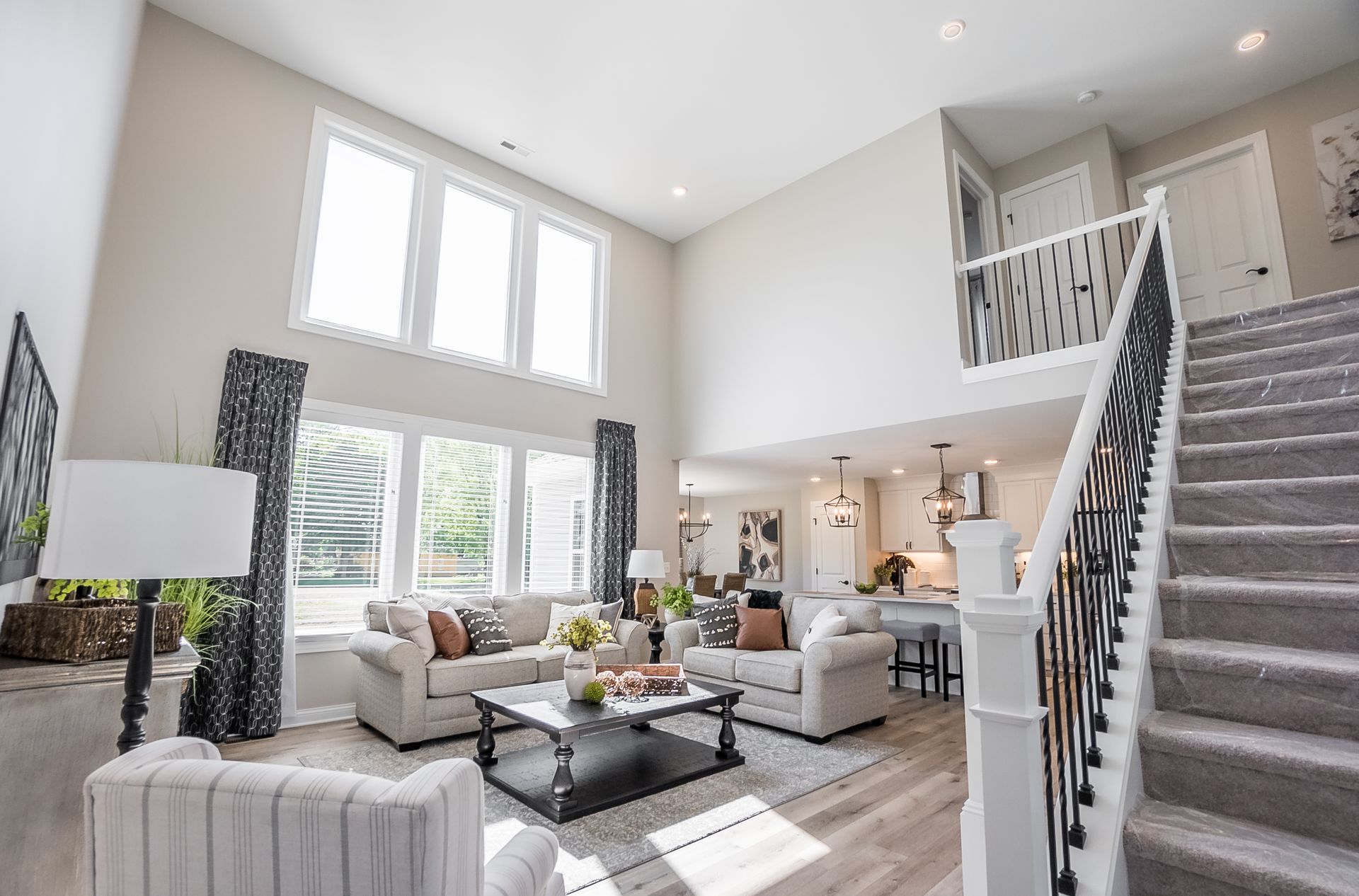 A living room with a staircase leading up to the second floor.