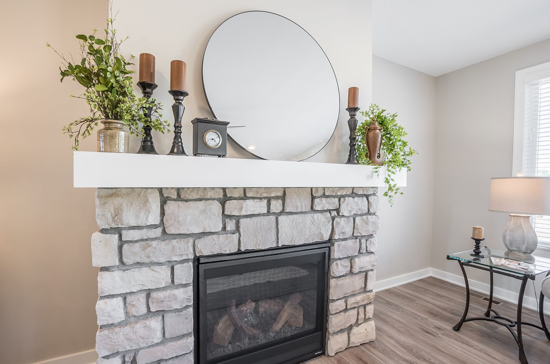 A living room with a fireplace and a mirror on the mantle.
