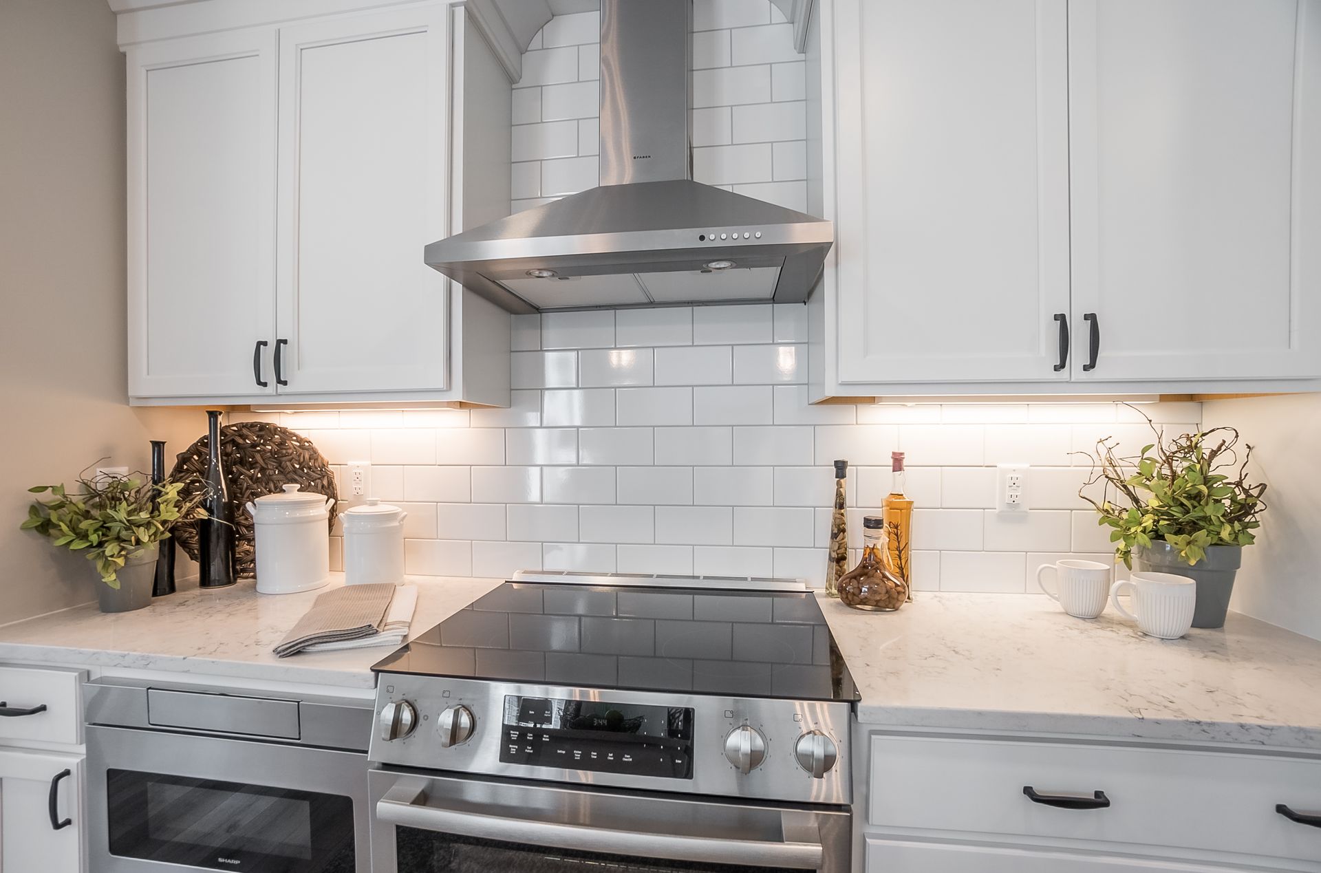 A kitchen with stainless steel appliances and white cabinets.