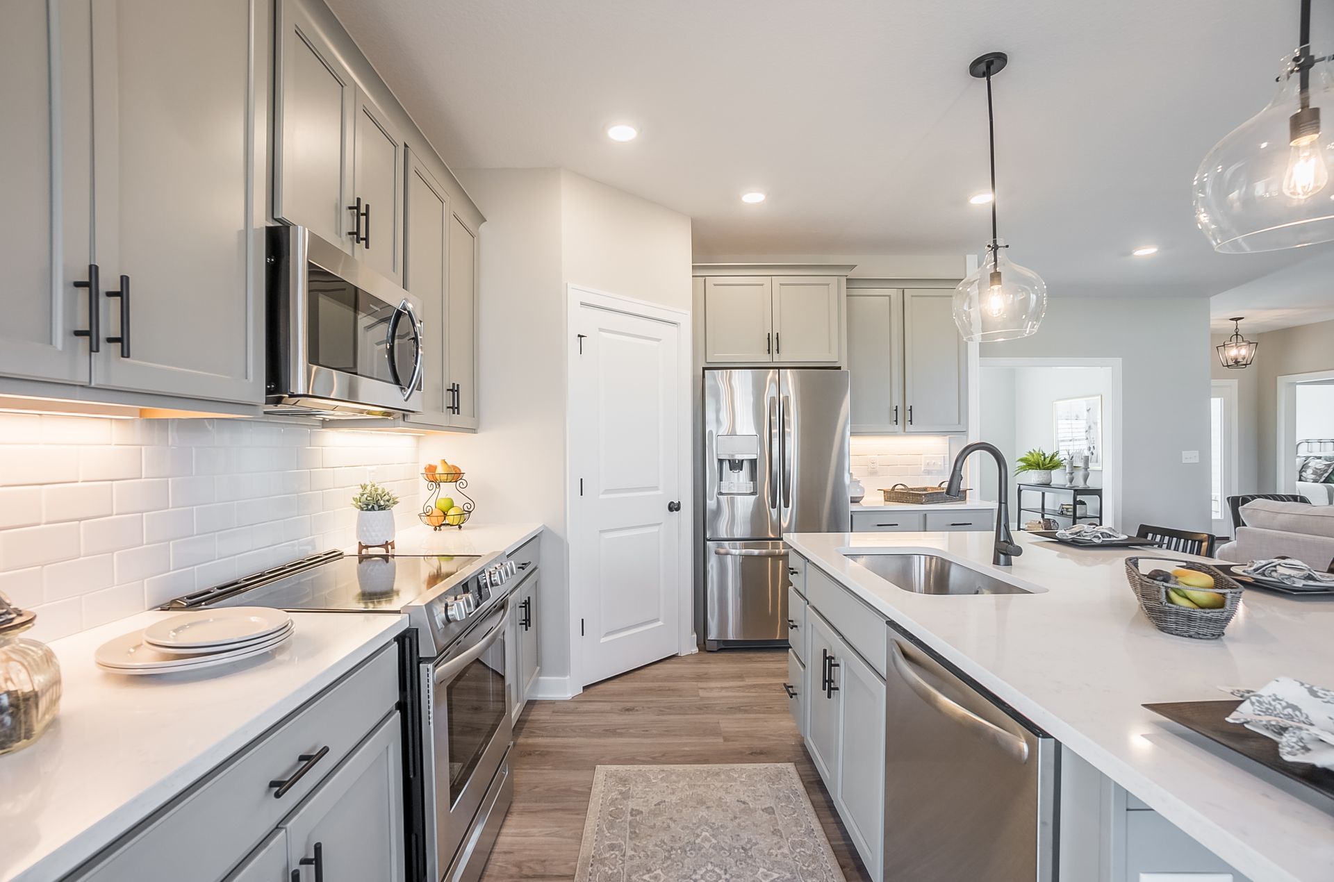 A kitchen with stainless steel appliances and white cabinets.