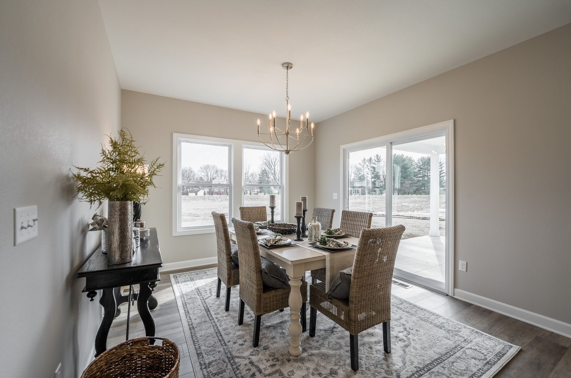A dining room with a table and chairs and a rug.