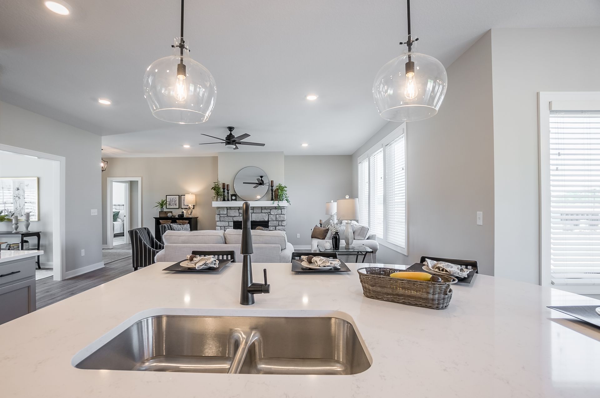 A kitchen with a sink and a living room in the background.