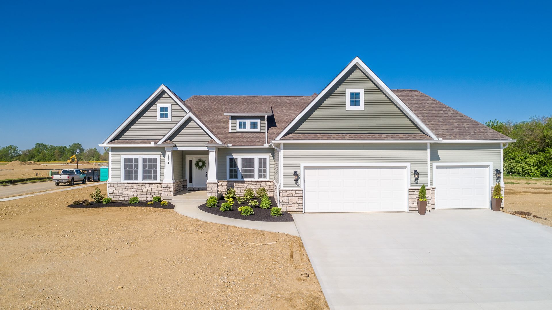 An aerial view of a large house with two garages and a driveway.