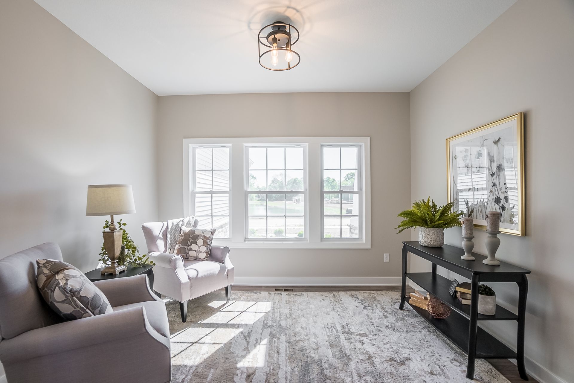 A living room with two chairs , a couch , and a table.