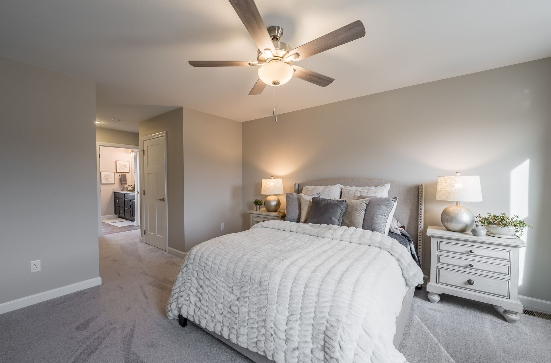 A bedroom with a bed , nightstand , and ceiling fan.