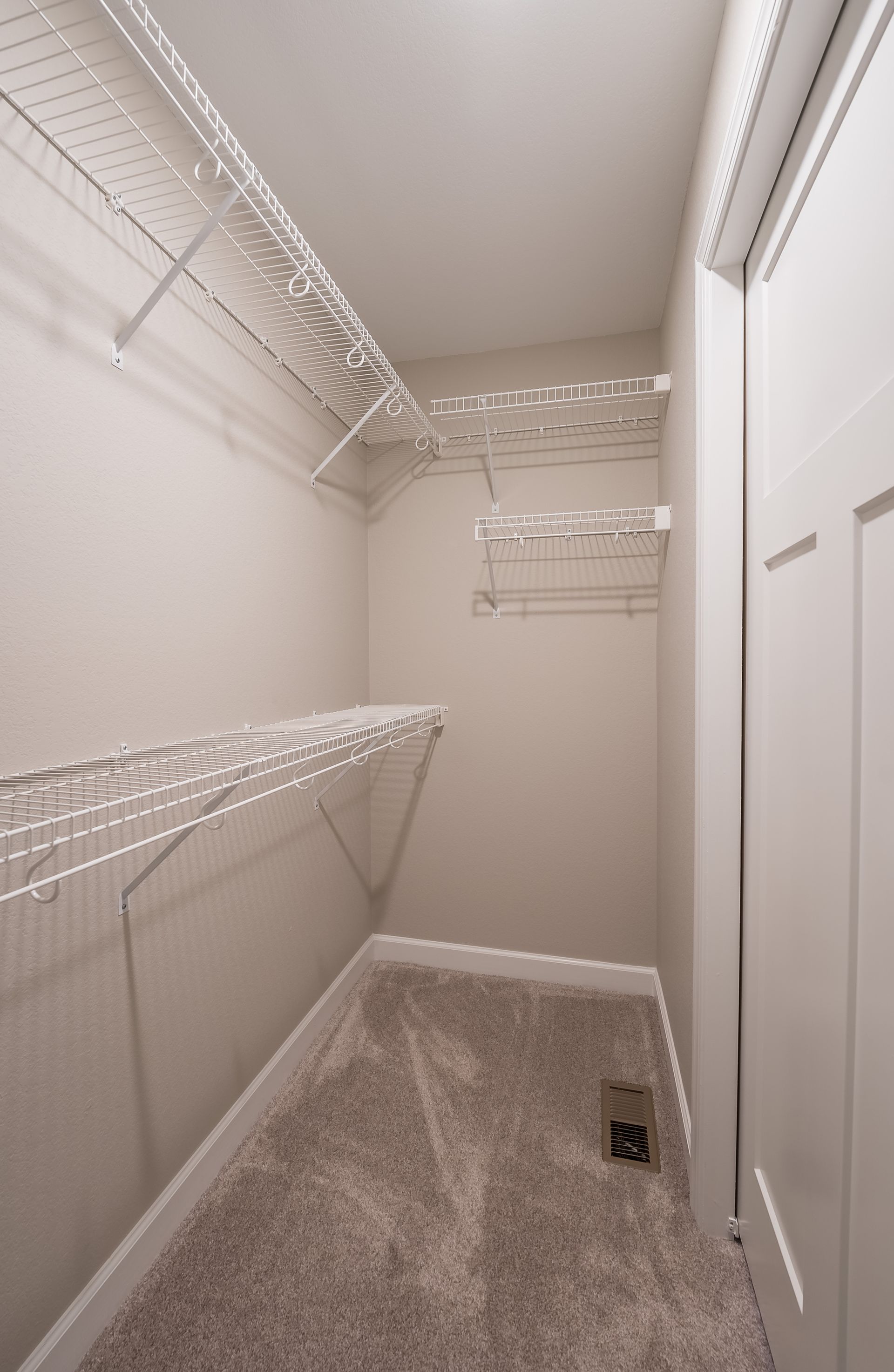 A walk in closet with lots of shelves and a door.