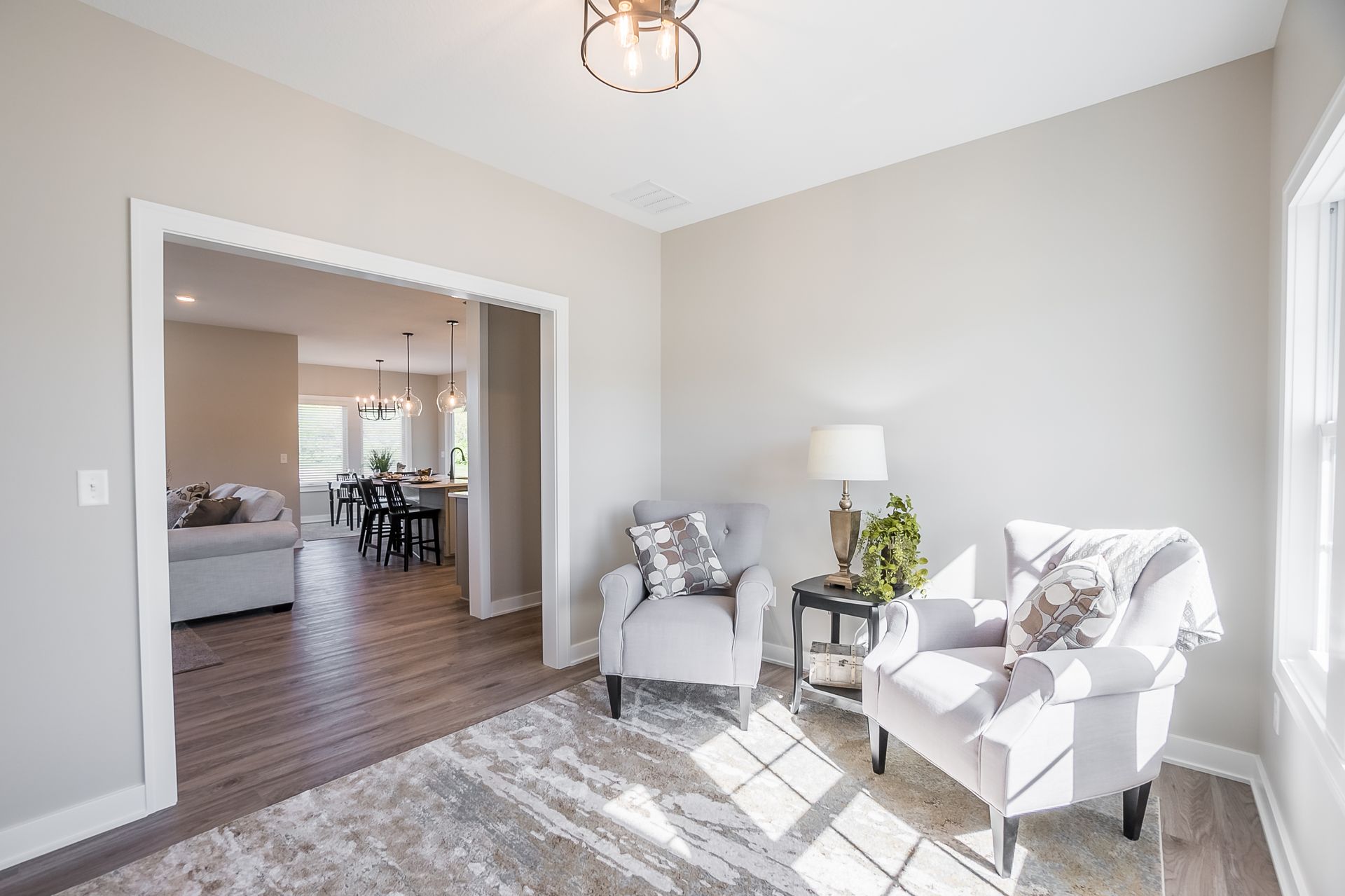 A living room with two chairs , a table and a lamp.