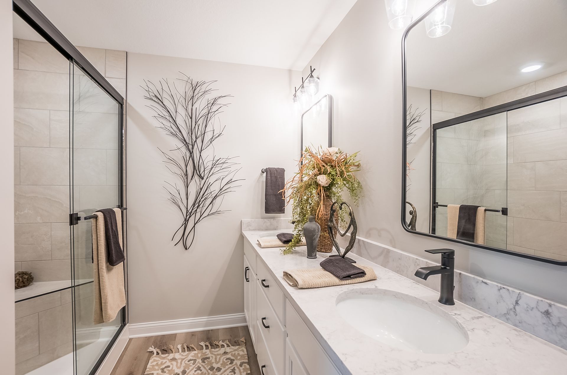 A bathroom with a sink , mirror and walk in shower.