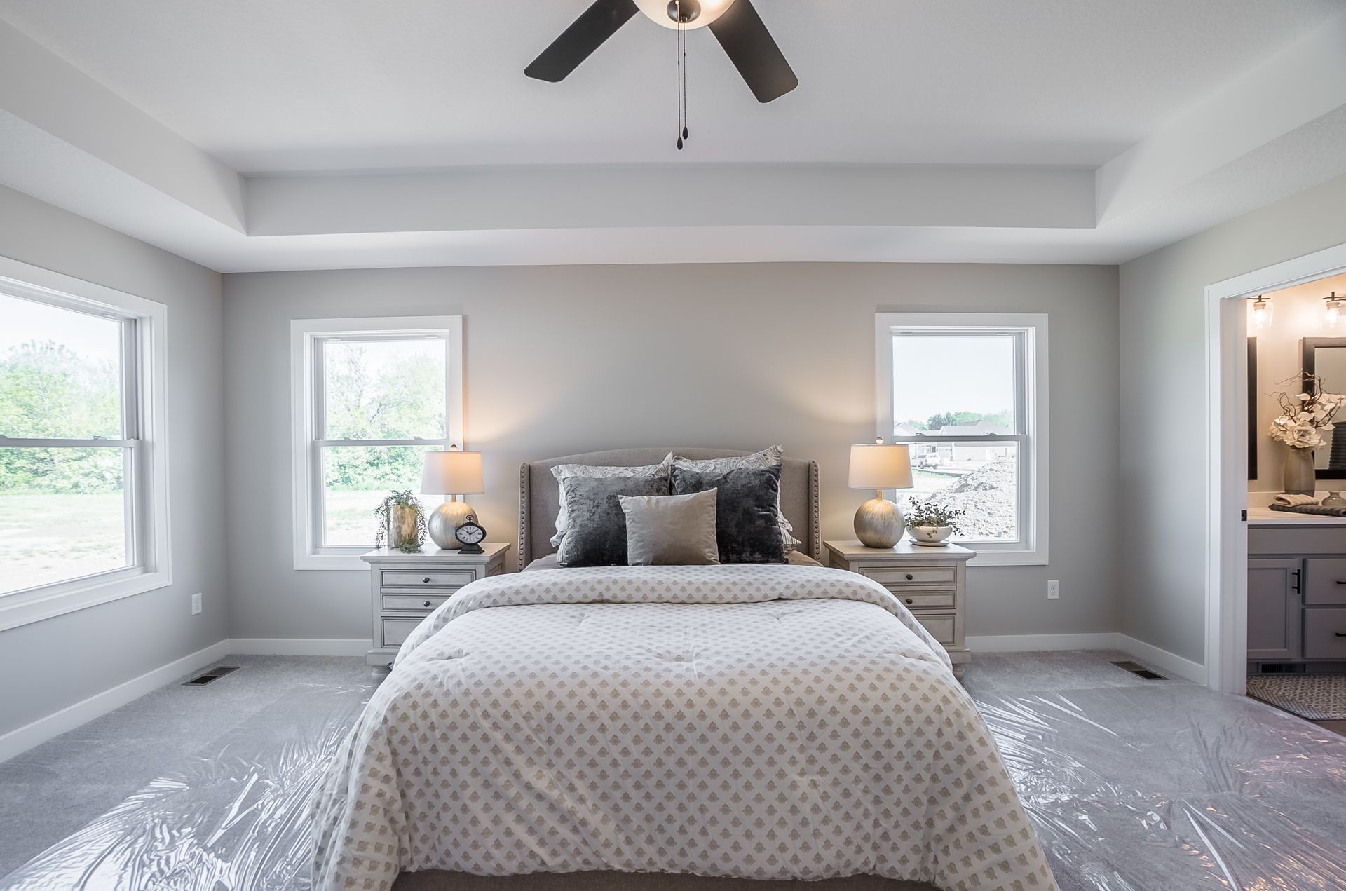 A bedroom with a bed and a ceiling fan.