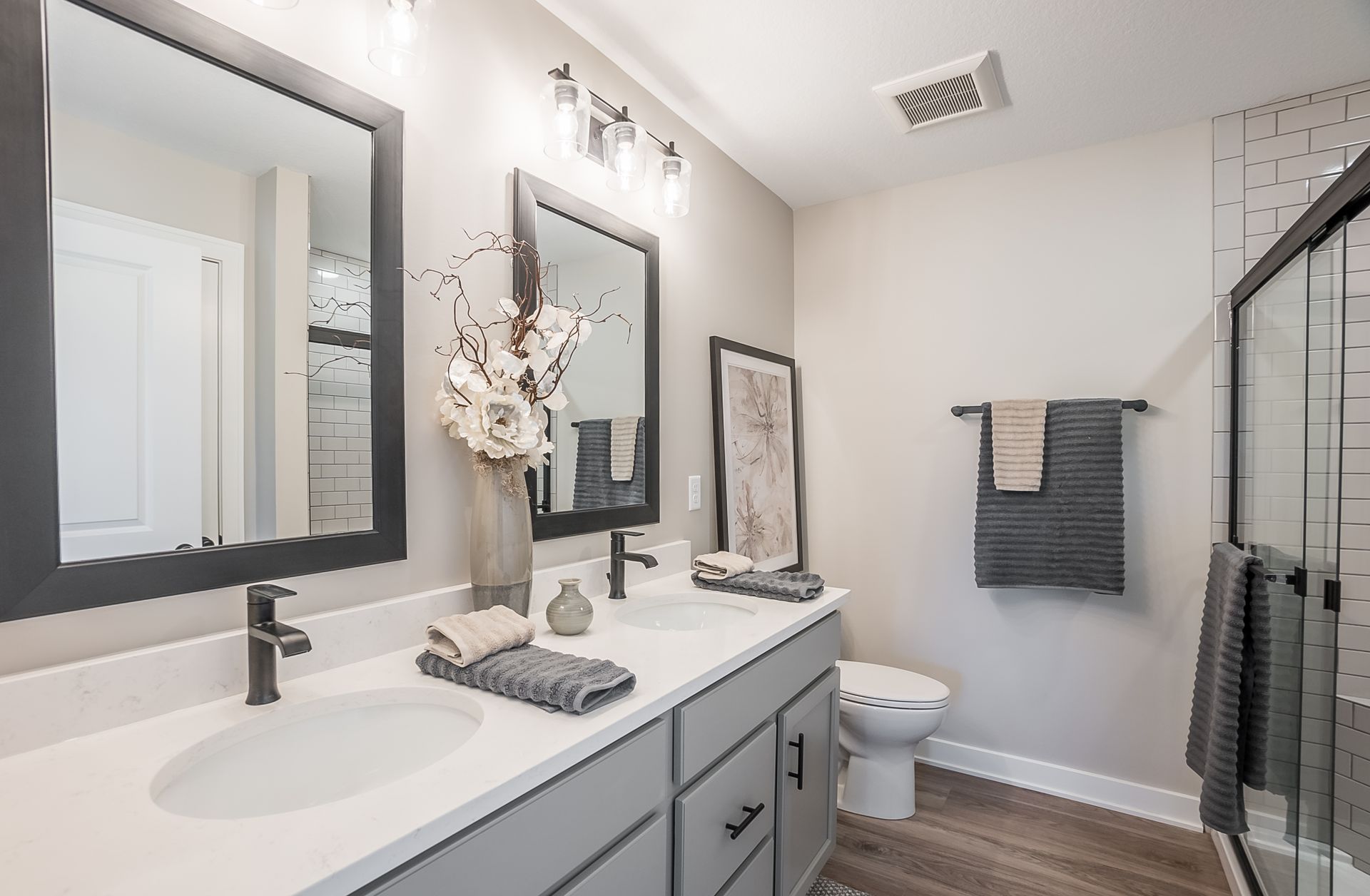 A bathroom with two sinks , a toilet , and a shower.
