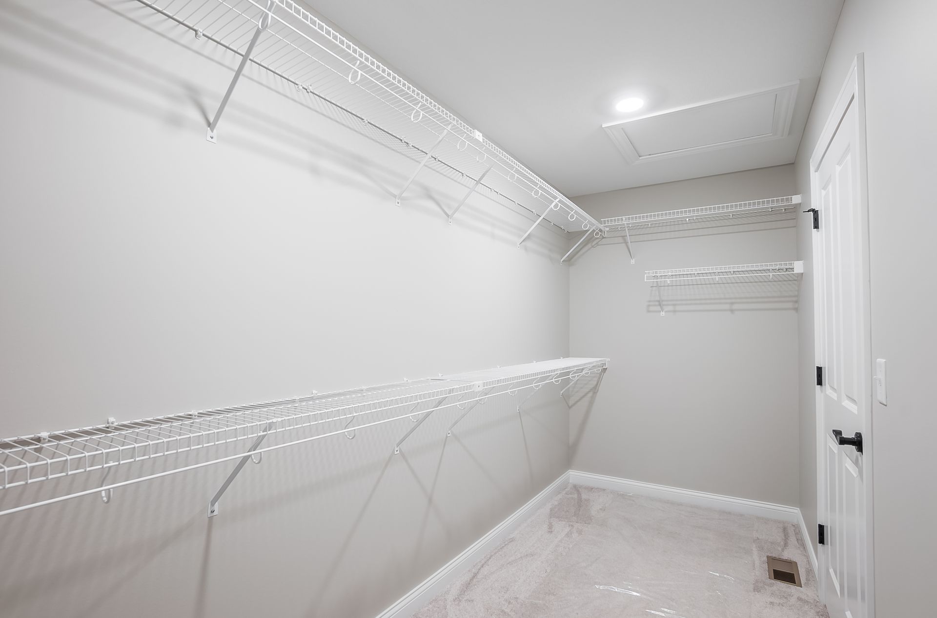 A walk in closet with lots of shelves and clothes racks.