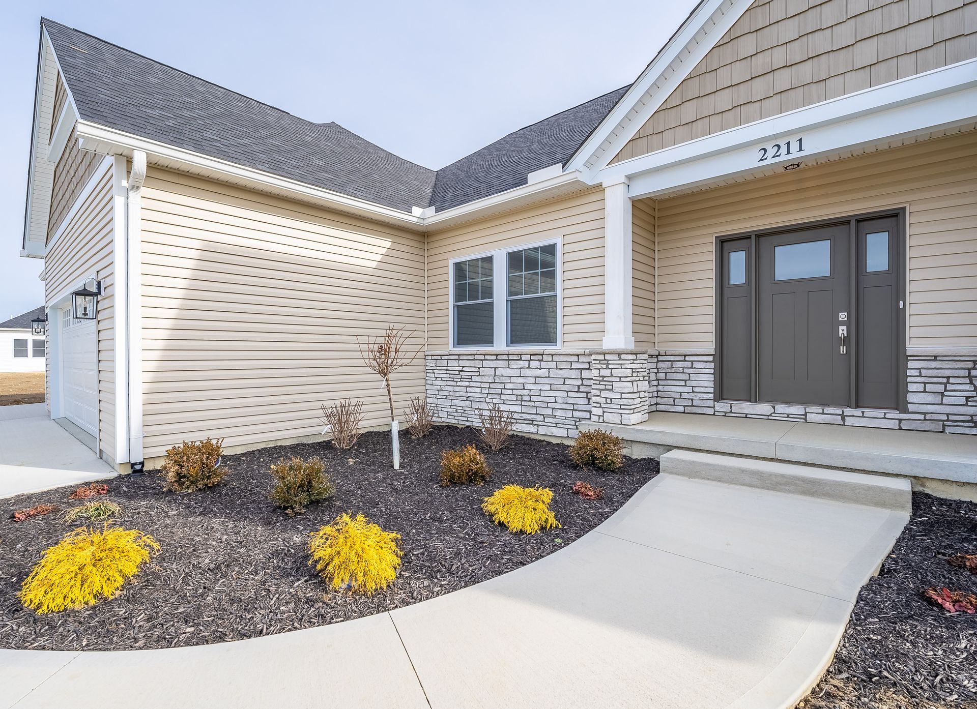 A house with a concrete walkway leading to the front door