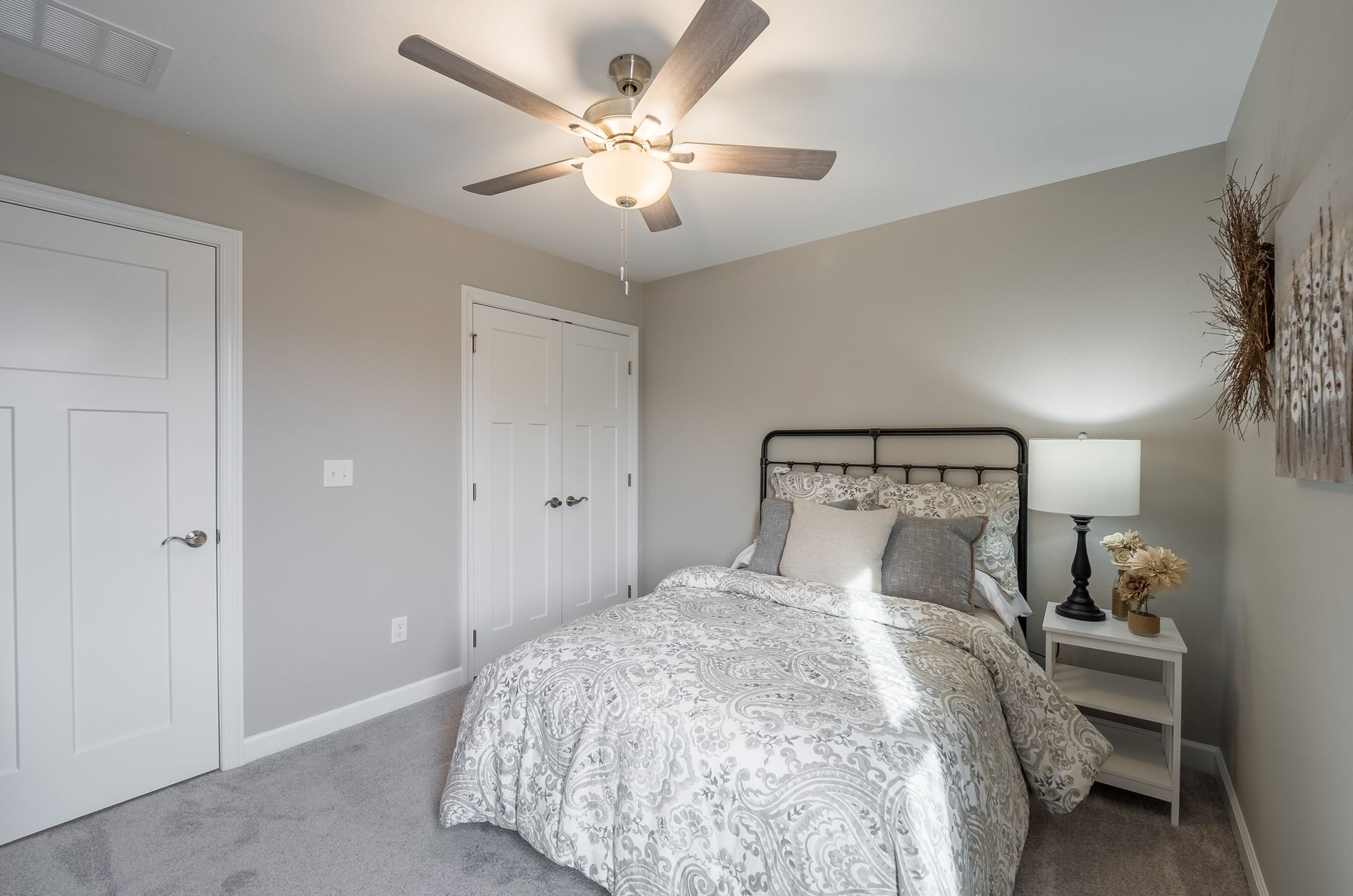 A bedroom with a bed and a ceiling fan.