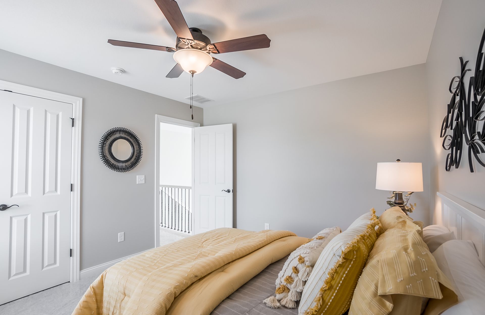 A bedroom with a bed and a ceiling fan.